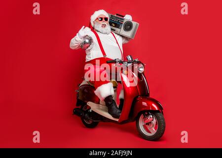 Porträt Seiner er schön Heiter Heiter unbeschwerte funky Santa tragen cap Hut Kopfbedeckung reiten Motorrad Durchführung boombox Spaß isoliert Bärtigen Stockfoto