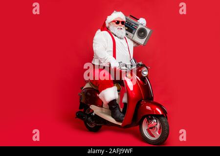 Portrait von Nizza bärtigen fröhliche Fett großen Bauch funky Santa hipster tragen festlichen Gap hut Kopfbedeckung reiten Motorrad Durchführung boombox auf isolierte Stockfoto