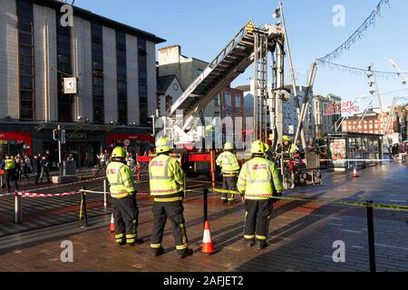 Cork, Irland. 16 Dez, 2019. Klumpen des konkreten Falls von Gebäude auf St. Patrick's Street, Cork City. Kurz nach 1 Uhr heute ein Stück Beton von oben Debenhams auf den St. Patricks Street zurück. Der Brocken aus dem Überhang an der Oberseite der Gebäude beschädigt und fiel zu Boden. Es wird geglaubt, dass niemand während der verletzt wurde. Die Stadt Cork Feuer Brücke und eine Gardai Shiochana abgeschlossenen Teil der Straße und sind assesseing den Schaden nicht mehr gewährleistet ist, zu fallen. Credit: Damian Coleman/Alamy leben Nachrichten Stockfoto