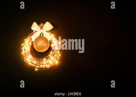 Glühende Kreis von girlande Weihnachten Spielzeug auf schwarzen Hintergrund mit glitzert Stockfoto