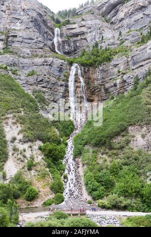 Eine mehrstufige Wasserfall in Provo Canyon, Bridal Veil Falls, fließt durch den Berghang, während Menschen auf Schauen und Erkunden Stockfoto