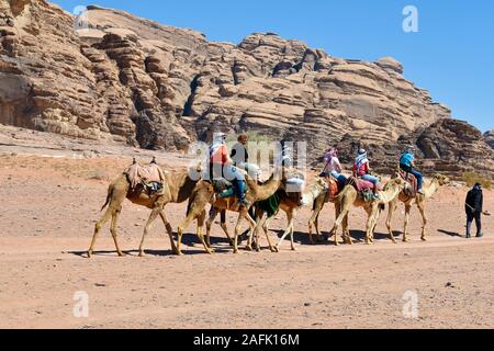 Wadi Rum, Jordanien - März 07, 2019: Unbekannter Touristen auf Kamelritt in der UNESCO-Weltkulturerbe im Nahen Osten Stockfoto