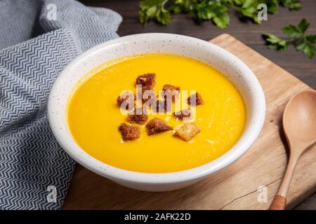 Karotten creme Suppe mit Croutons auf hölzernen Tisch. Gesunde Ernährung Stockfoto