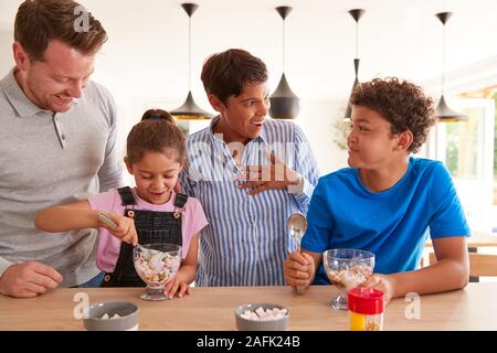 Familie mit Kindern, die in der Küche und essen Eis Desserts Stockfoto