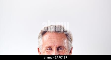 Studio Shot reifer Mann gegen weißen Hintergrund Lachen Kamera 7/8 unter Augen Stockfoto