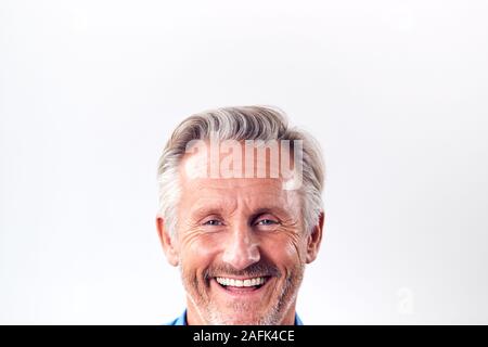 7/8 Studio Shot reifer Mann gegen weißen Hintergrund Lachen an Kamera Stockfoto