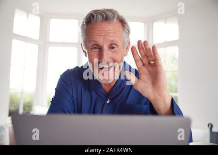 Reifer Mann in Online-Beratung mit Arzt zu Hause auf dem Laptop Stockfoto