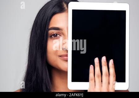 Studio Portrait von ernsthaften jungen Frau mit Gesicht mit digitalen Tablet Stockfoto