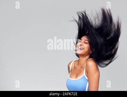 Studio Portrait von Positiven glückliche junge Frau lange Haare streichen Stockfoto