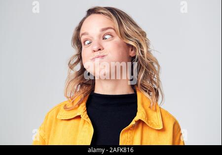 Kopf und Schultern Studio Shot von Frau, Grimassen und lächelnd an Kamera Stockfoto