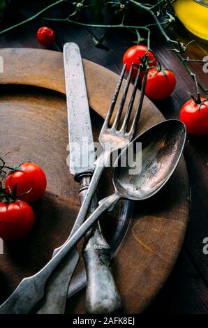 Vintage Tisch mit alten silbernen Löffel, Gabel und Messer in dunklen Holz- Platte von oben. Kreative Thanksgiving Abendessen noch leben. Restaurant Silve Stockfoto