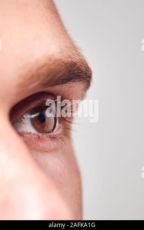 Extreme Nahaufnahme von Auge des Menschen gegen Weiße Studio Hintergrund Stockfoto