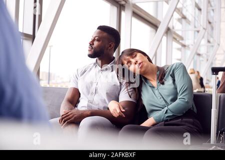 Müde Geschäft Paar durch Fenster Warten im Flughafen Abflughalle Stockfoto