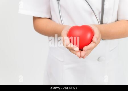 Wenig Ärztin mit Stethoskop holding Herz auf weißem Hintergrund, Health Care Konzept Stockfoto