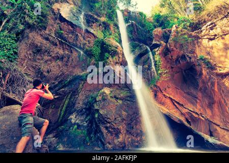 Glückliche Menschen Backpacker genießen erstaunlichen tropischen Wasserfall erhobenen Händen Reisen Lifestyle und erfolg konzept Ferien in der wilden Natur Stockfoto