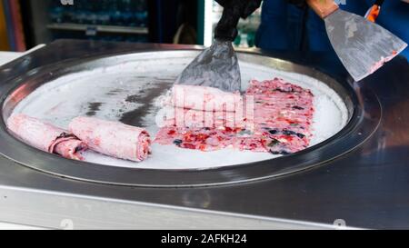 Thailand süße Lebensmittel Straße rühren - gebratenes Eis rollt mit freeze Pan. Konzept der organischen, natürlichen gerollt Eis, Dessert. Stockfoto