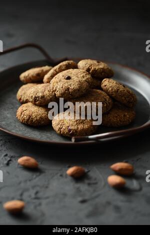 Glutenfrei Zuckerfrei veganen Süßigkeiten. Hausgemachte Mandelplätzchen in Vintage metall Fach auf schwarzem Hintergrund Kopie Raum Stockfoto