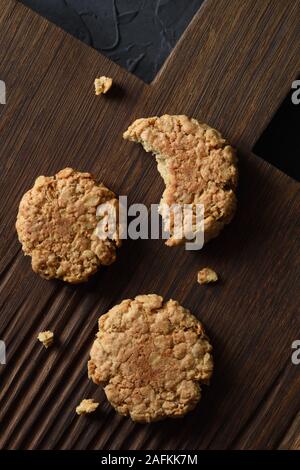 Home Backen. Gesunde oatmeal Cookies auf dunkle Eiche Schneidbrett Top View Stockfoto