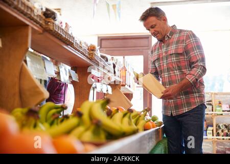 Männliche Kunden mit Papiertüte kaufen frische Birnen in organischen Farm Shop Stockfoto