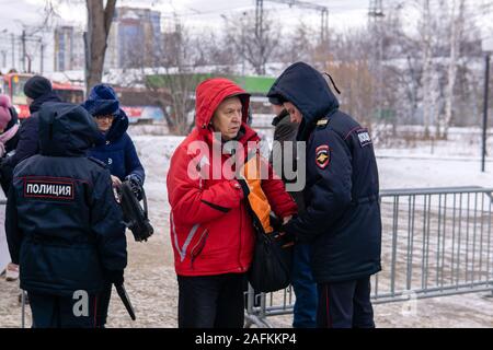 Perm, Russland - Dezember 14, 2019: Russische Polizisten prüfen für verbotene Gegenstände der Bürgerinnen und Bürger zu einem autorisierten Rallye gehen Stockfoto