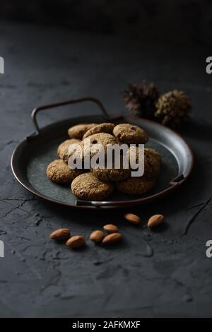 Glutenfreie gesunde vegane Nachspeise. Haufen Energie beißt in Vintage metall Fach und ganzen Nüssen auf schwarzem Hintergrund Seitenansicht kopieren Platz Low Key noch li Stockfoto