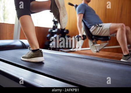 Detail der Paar in Home Gym Training mit Gewichten und mit laufender Maschine Stockfoto