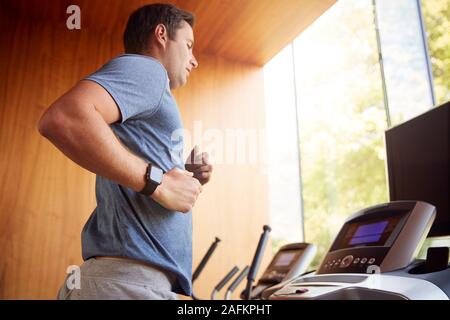 Mann Ausübung auf Laufband zu Hause tragen Smart Watch Stockfoto