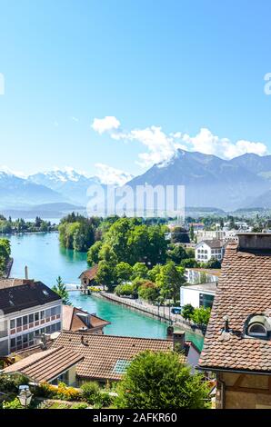 Stadtbild der historischen Stadt Thun in der Schweiz. Die historische Altstadt von Türkis Aare gelegen. Schweizer Alpen mit schneebedeckten Bergen im Hintergrund. Stockfoto