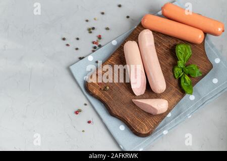 Würstchen zum Frühstück und Hot Dogs. Auf einem hellen Hintergrund. In der Nähe befinden sich Blätter Basilikum. Stockfoto