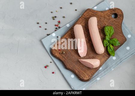 Würstchen zum Frühstück und Hot Dogs. Auf einem hellen Hintergrund. In der Nähe befinden sich Blätter Basilikum. Stockfoto