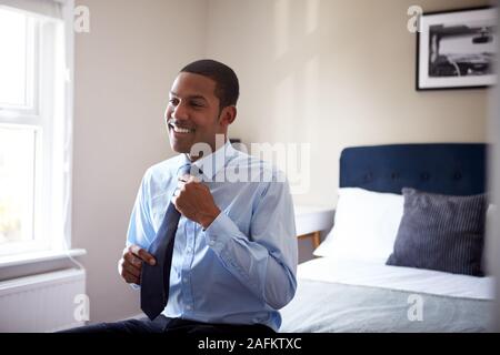 Junger Mann, gekleidet in Schlafzimmer für ersten Tag bei der Arbeit im Büro Stockfoto