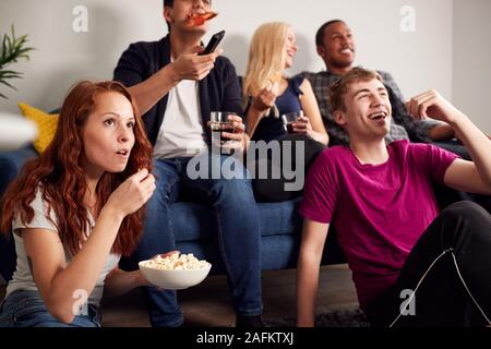 Gruppe Studenten im gemeinsamen Haus Fernsehen und Essen Popcorn Stockfoto