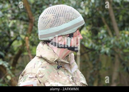 Britische Armee Soldat in der Armee Grüns camo Outfit, Jacke und Helm. Stockfoto