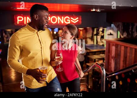 Paar auf Datum Treppensteigen als Sie Treffen für Getränke und gesellig in Bar Stockfoto