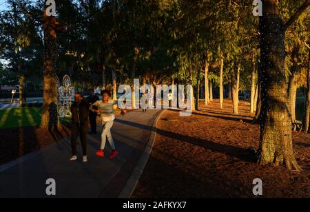 Menschen gehen um den Lake Eola Park mit festlichen Dekorationen in Orlando, Florida. Stockfoto