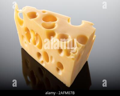 Schweizer Käse mit großen Löchern auf dunklem Hintergrund isoliert Stockfoto