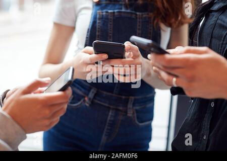 Nahaufnahme von Unternehmerinnen mit Handys in modernen Büro Stockfoto