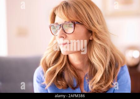 Close-up Portrait von Frau mittleren Alters nachdenklich auf der Suche beim Entspannen. Stockfoto