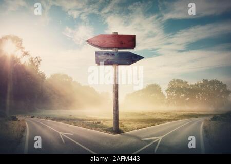 Surreale Landschaft mit einem Split Straße und Wegweiser Pfeile angezeigt, die zwei unterschiedliche Kurse, links und rechts Richtung zu wählen. Straße teilt in verschiedenen Dis Stockfoto