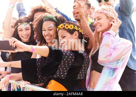 Junge Freunde im Publikum hinter der Barriere an Outdoor Musik Festival Posieren für Selfie Stockfoto