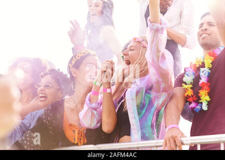 Publikum mit farbigen Rauch hinter Schranke Tanzen und Singen bei Outdoor Festival Musik genießen Stockfoto