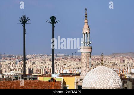 Handy Turm wie eine Palme neben einem Minarett einer Moschee in der neuen Satelliten Stadt 6 th getarnt. Oktober in der Nähe von Kairo, Ägypten Stockfoto