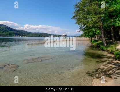 Ein Boot geparkt am Ufer eines Sees. Das Wasser des Sees ist kristallklar, die unten zu sehen ist. Auf der Rückseite gibt es einige Berge. Klare und b Stockfoto