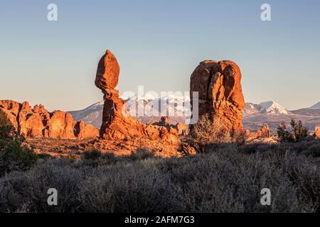 Balanced Rock, schneebedeckten La Sal Mountains im Hintergrund, Arches National Park, Moab, Utah USA Stockfoto