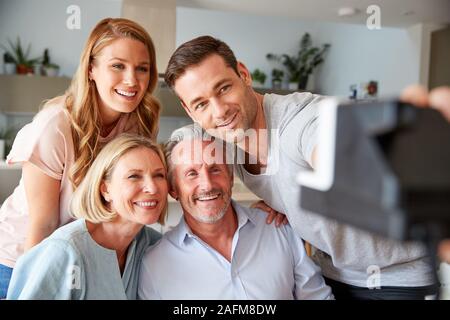 Ältere Eltern mit erwachsenen Nachkommen Posieren für Selfie auf Vintage Instant Film Kamera Stockfoto