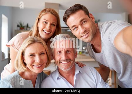 Ältere Eltern mit erwachsenen Nachkommen Posieren für Selfie zu Hause Stockfoto