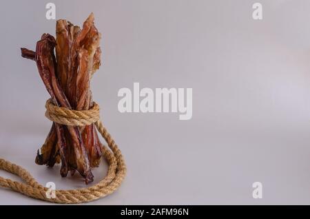 Natürliche Leckerbissen für Hunde. Getrocknetem Rindfleisch Sehne auf einem hellen Hintergrund. Kauen behandelt für Haustiere. Close-up. Kopieren Sie Platz. Die horizontale Version des Bildes Stockfoto