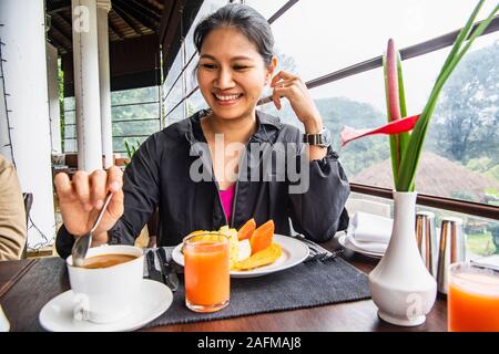 Frau mit einem gesunden Frühstück mit tropischen Früchten Stockfoto