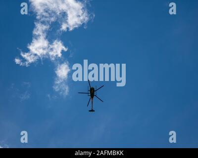 Bild von Fliegender Hubschrauber mit blauem Himmel von unten Stockfoto