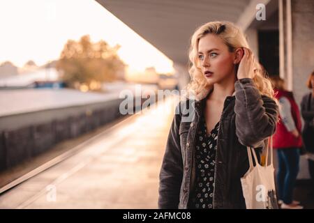 Nachdenkliche junge Frau wartet auf Zug in der Nähe der U-Bahn Station Stockfoto